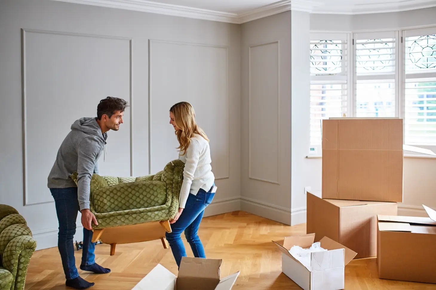 Couple moving furniture in new home.