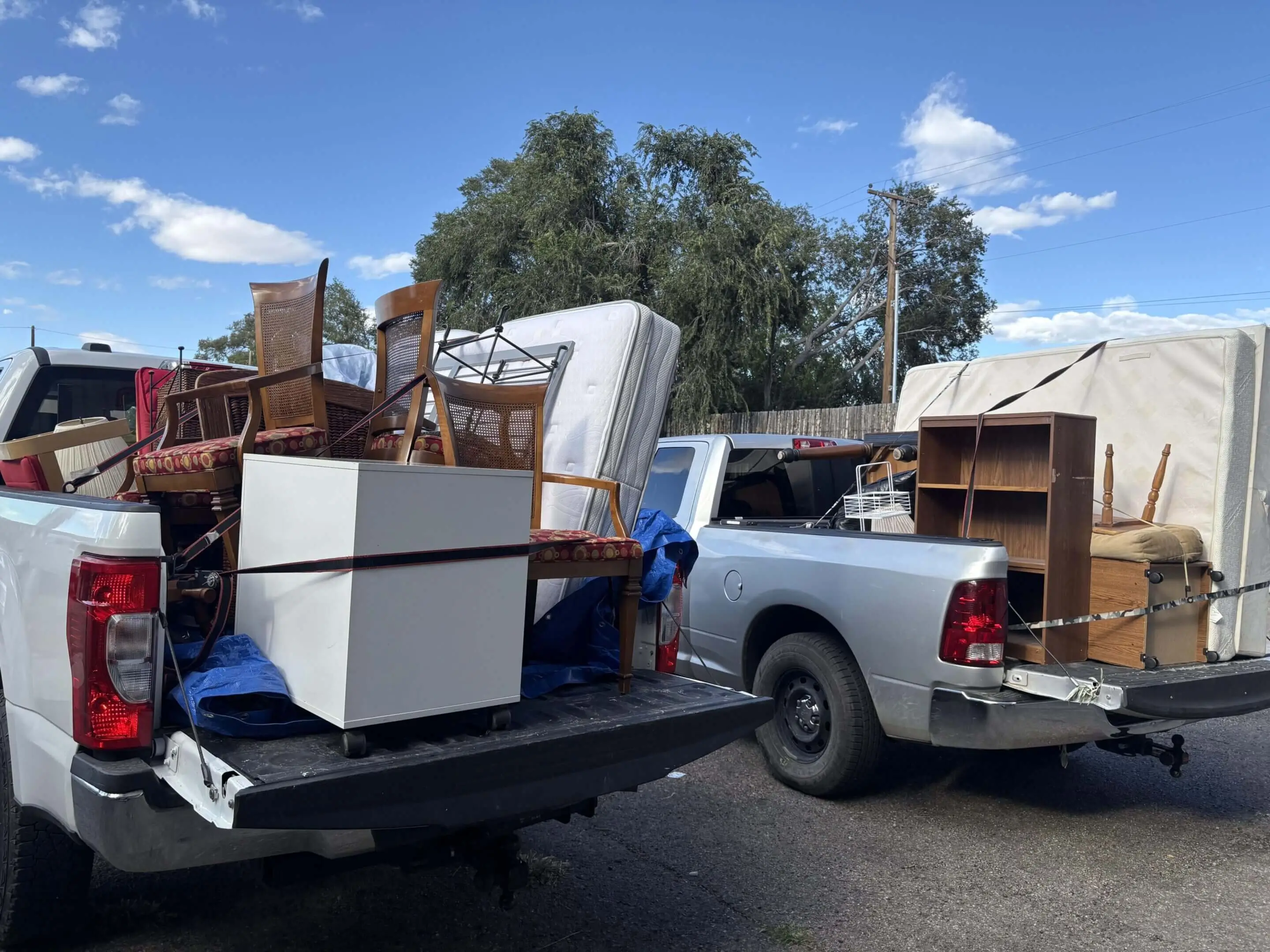 A pickup truck loaded with furniture and household items outdoors.